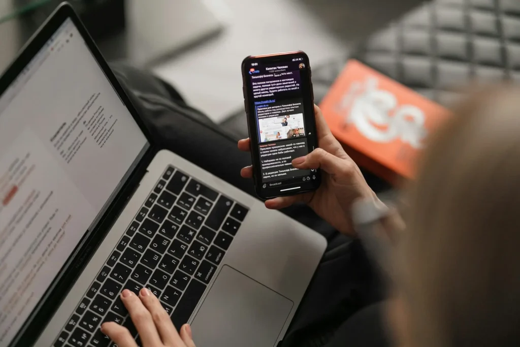 A person holding a smartphone, reading a news article displayed on the screen.