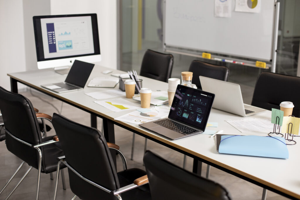 Collaborative digital marketing setup with open laptops, reports, and strategy tools